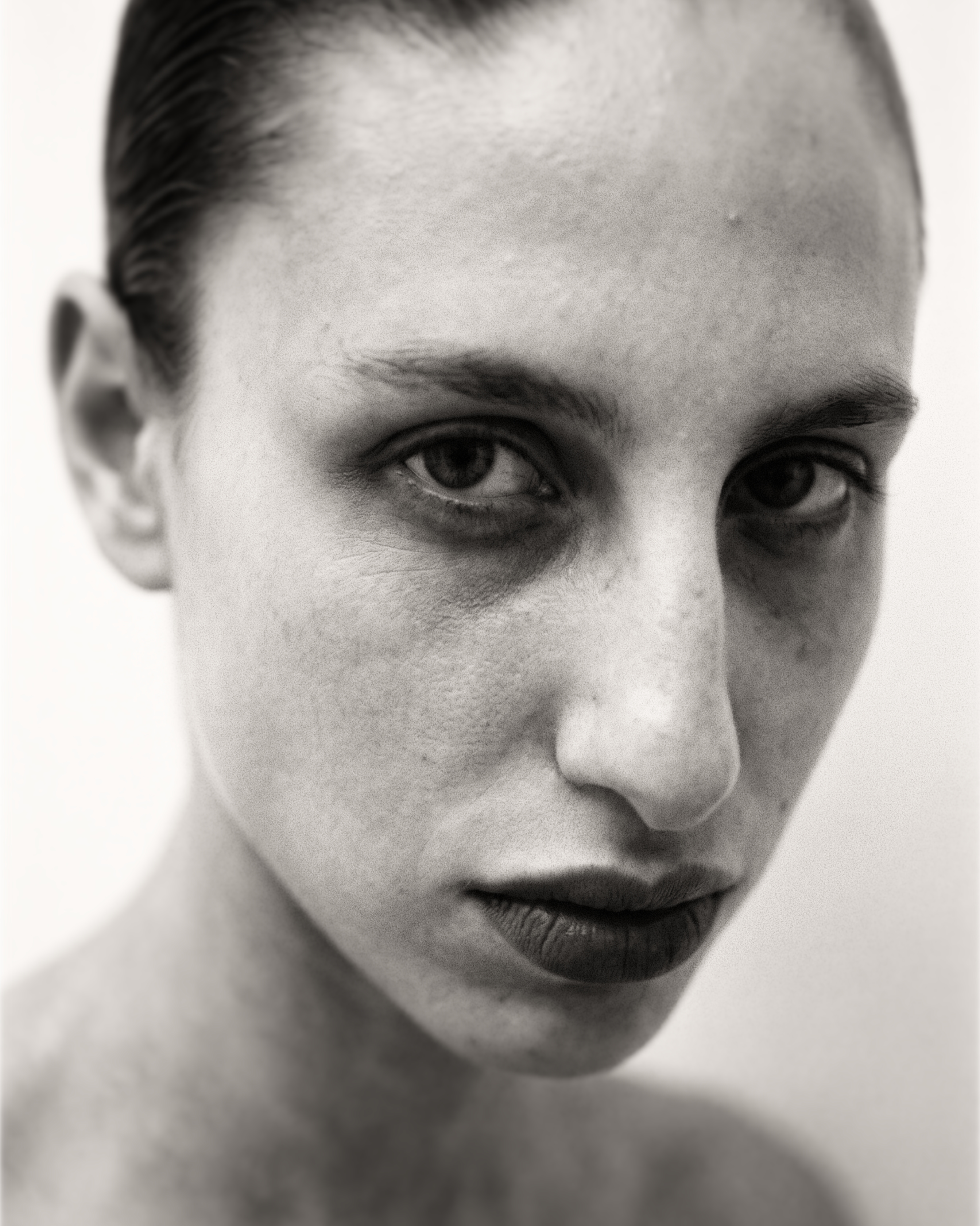 A close portrait, dark lip, unflinching gaze