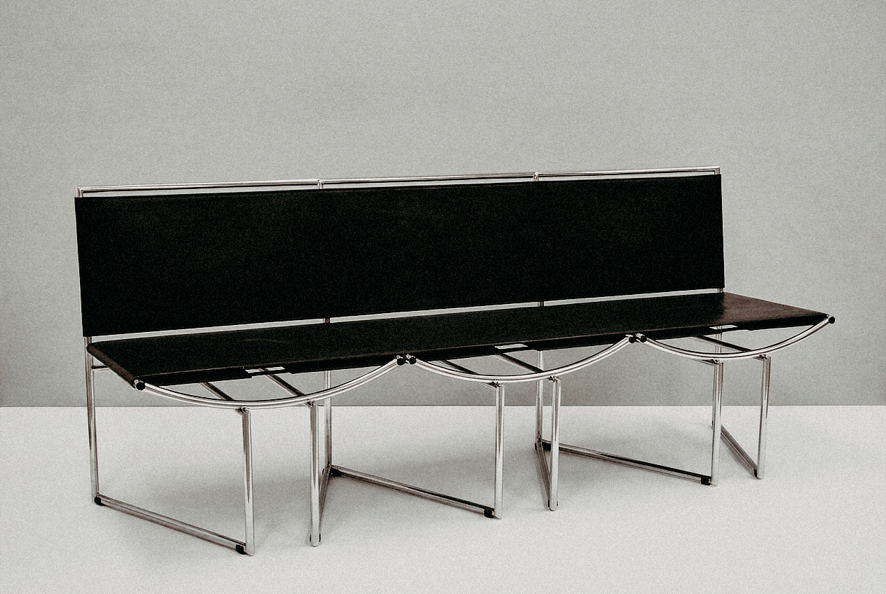 A tubular-steel bench with black upholstery, three seats
