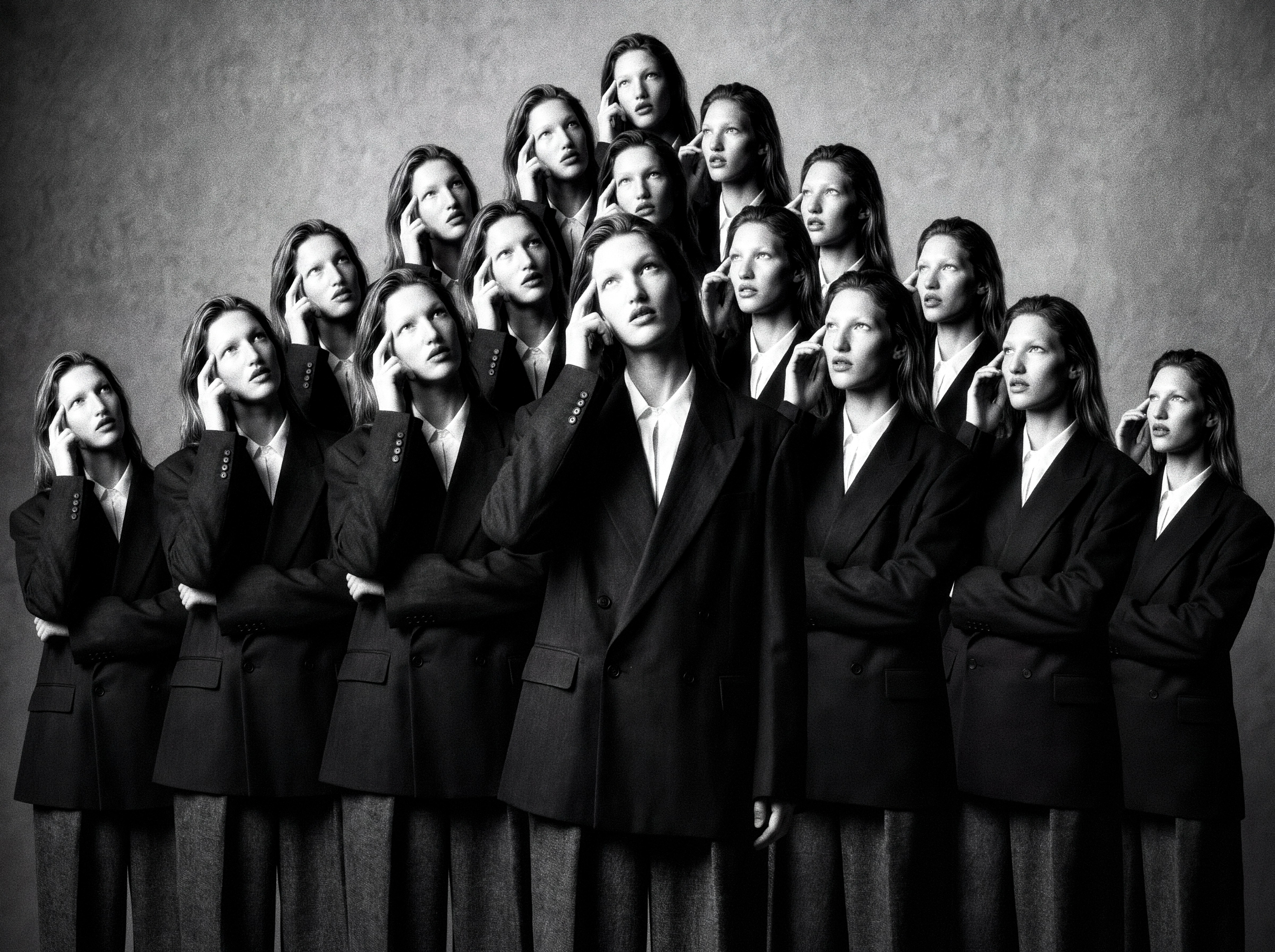 Calleoke — Black-and-white pyramidal chorus in tailored dark suiting holding a finger to the temple.