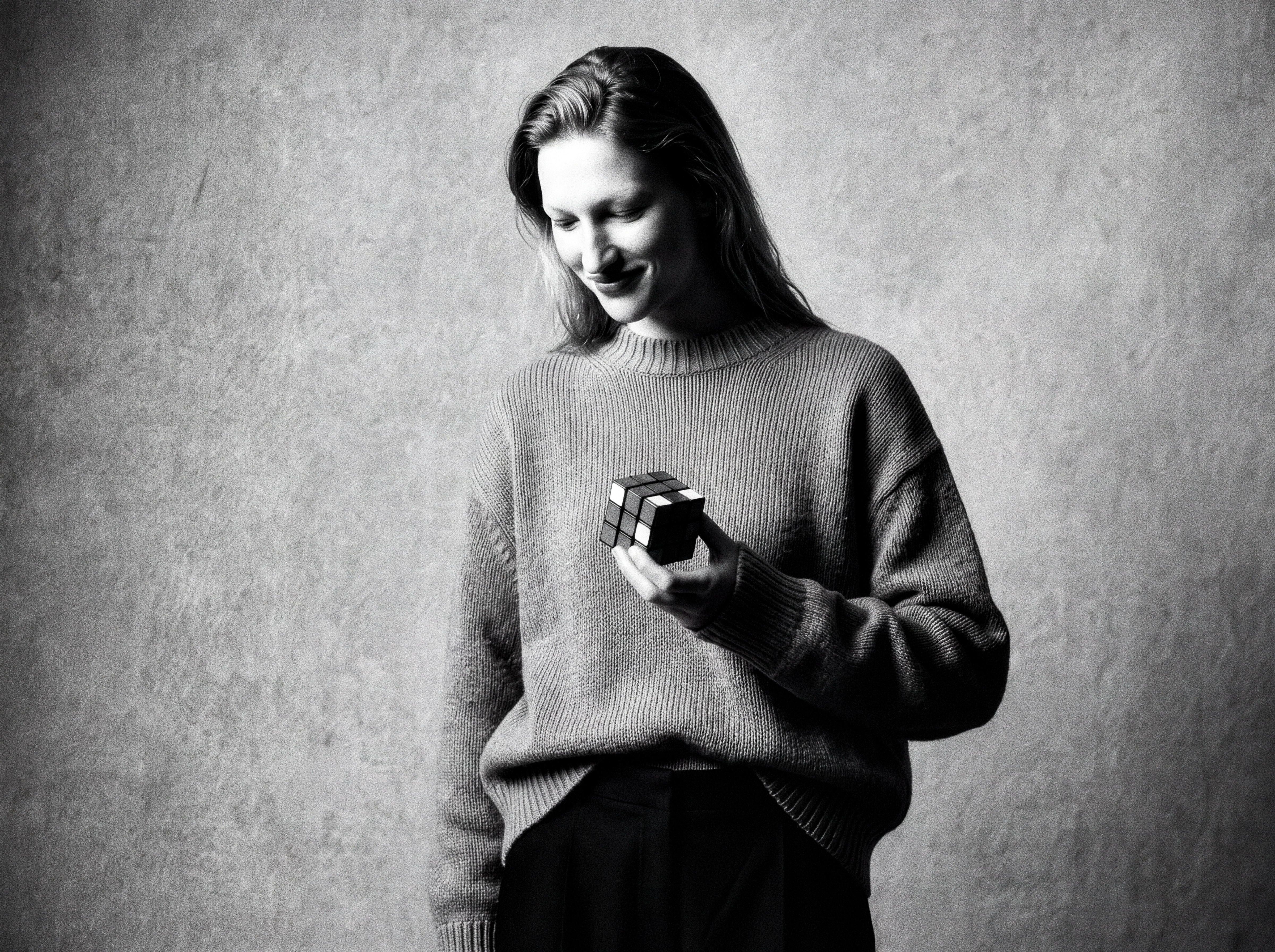 Calleoke — Black-and-white studio portrait in ribbed knitwear holding a monochrome cube.