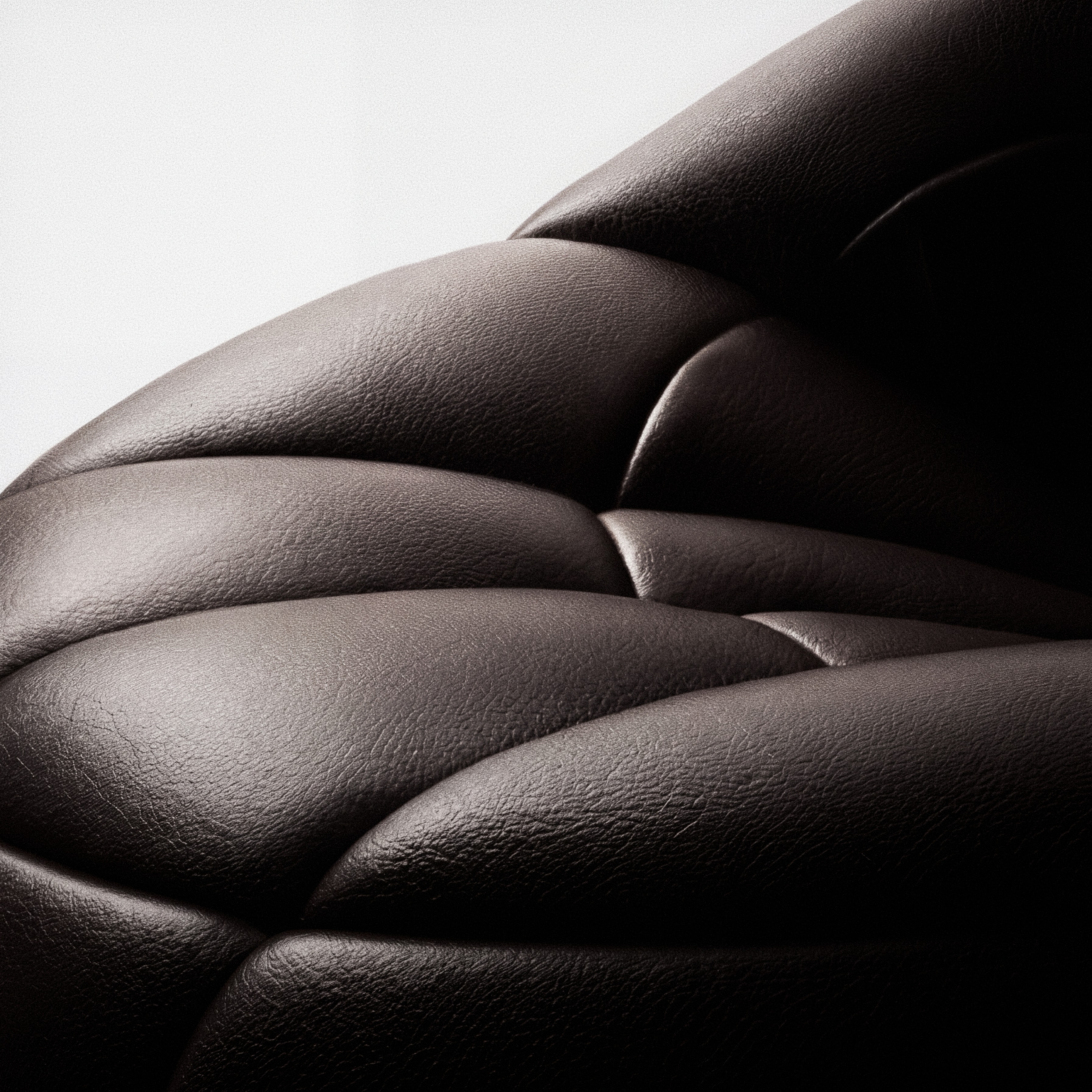 Godland Caldera lounge chair — three-quarter view of radial-quilted leather segments against a light studio ground.